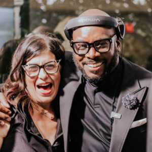 Smiling couple using props inside the luxury photo booth.