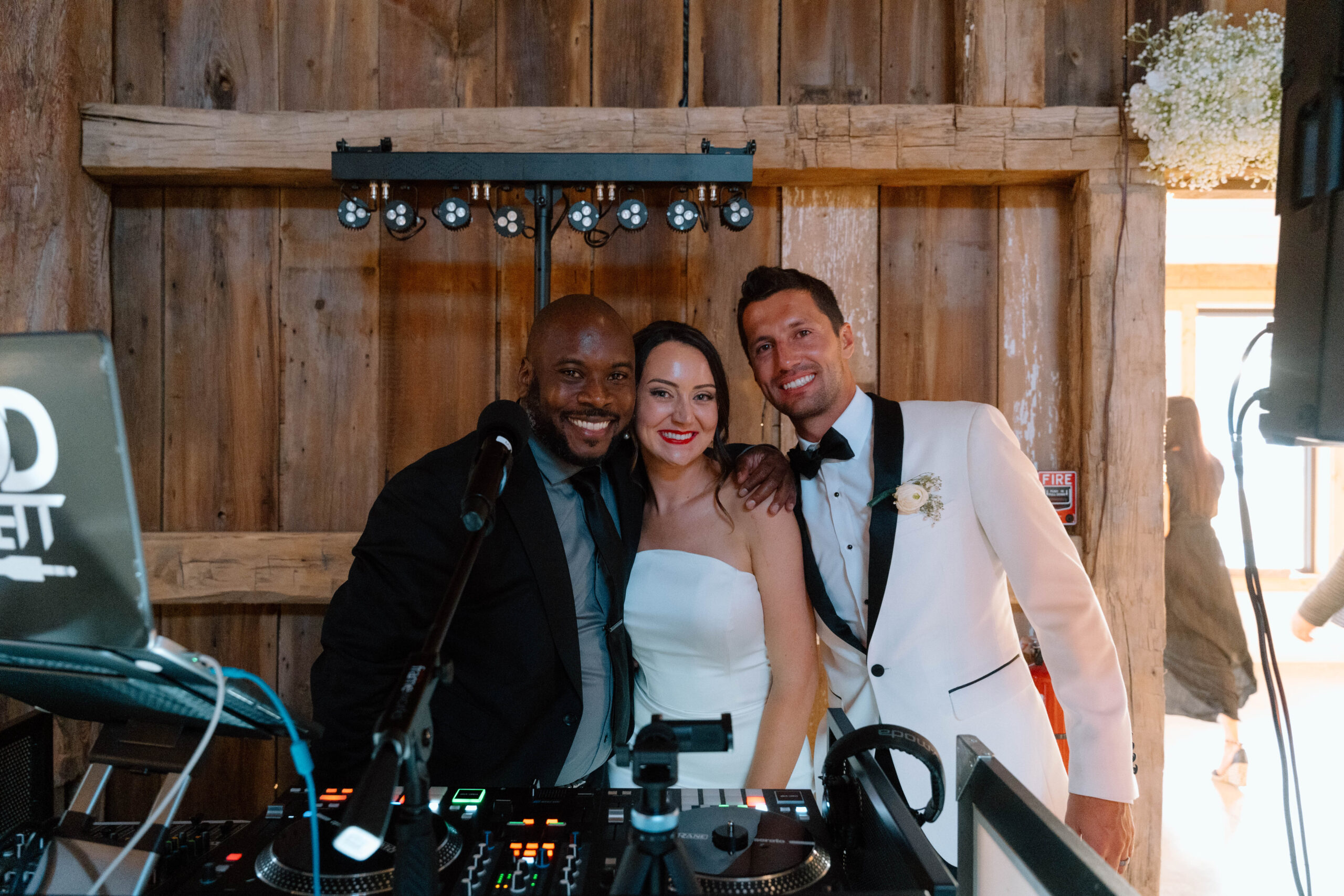 Todd Everett celebrating with bride and groom at their rustic barn wedding at The Glenn Royal Barn in Port Austin, Michigan